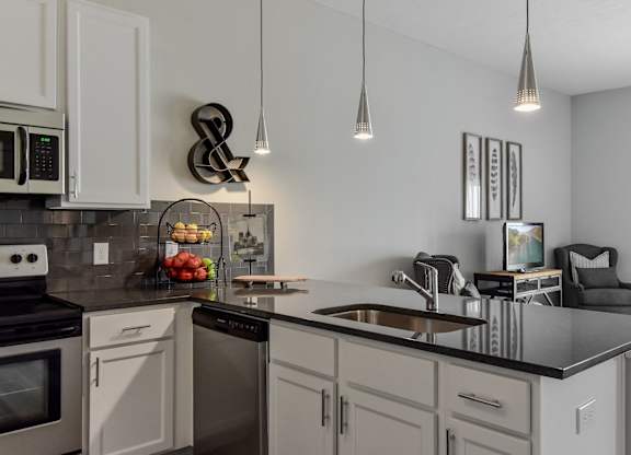 an open kitchen and living room with a large counter top
