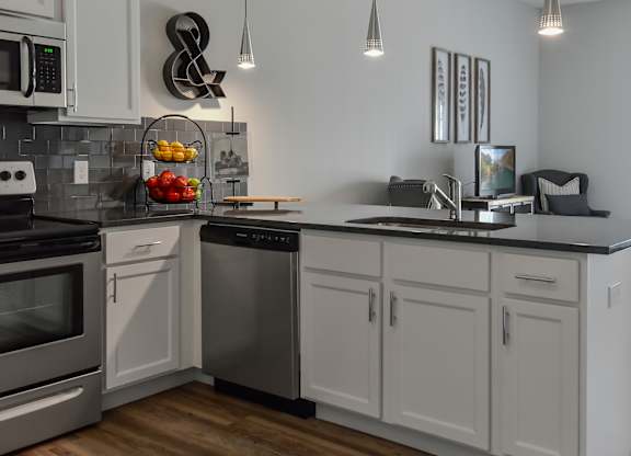a kitchen with white cabinets and stainless steel appliances