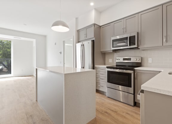 Modern kitchen with stainless steel appliances and white cabinetry.