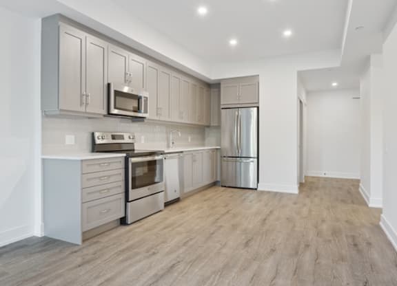 Kitchen with wooden floors and stainless steel appliances.