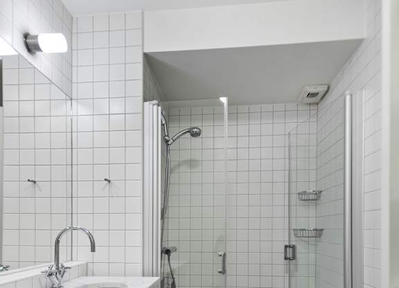 A white sink with a silver faucet is on a white countertop in a bathroom.
