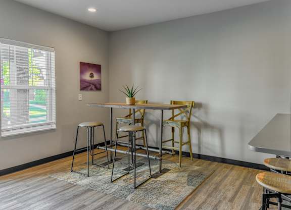 a dining area with a table and chairs and a window