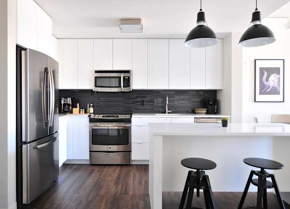 a kitchen with white cabinets and stainless steel appliances