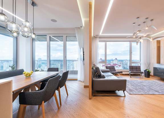 A modern living room with a dining table and chairs.