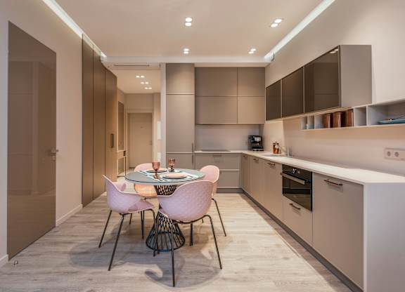 A modern kitchen with a dining table set for two.