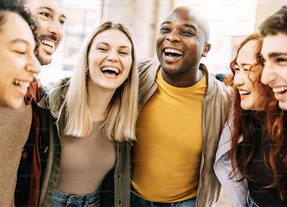 A group of people are standing close together and laughing.
