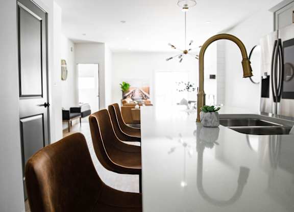 A modern kitchen with a long table and chairs.