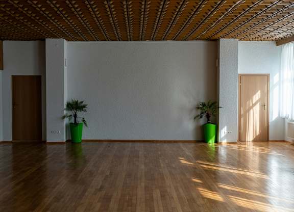 A room with wooden floors and a wooden ceiling with two green plants on it.