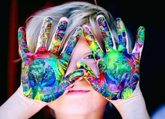 a woman holding her hands up with paint on them