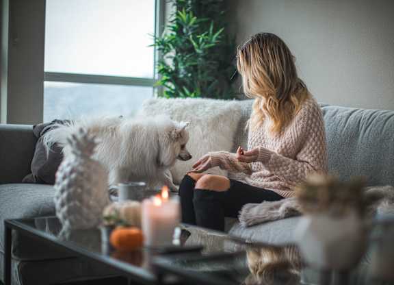 a woman sitting on a couch with her dog
