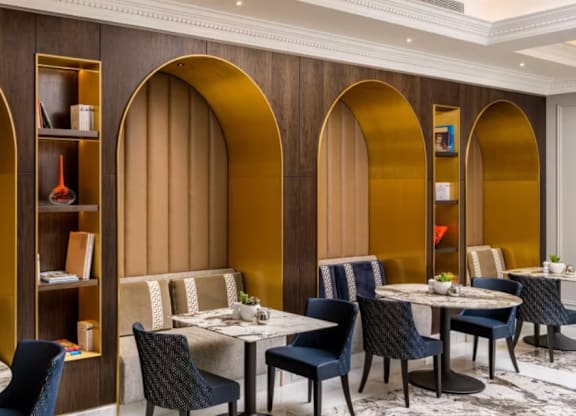 A restaurant with tables and chairs and arched wooden walls.