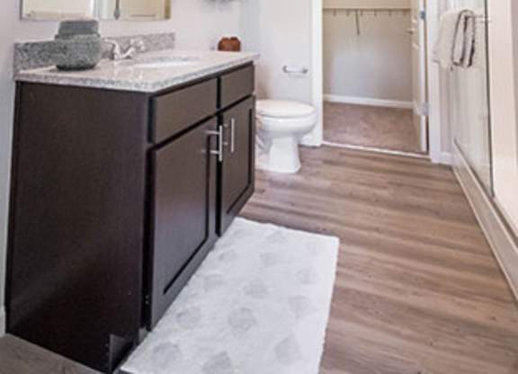 A bathroom with a toilet, sink, and a mirror.