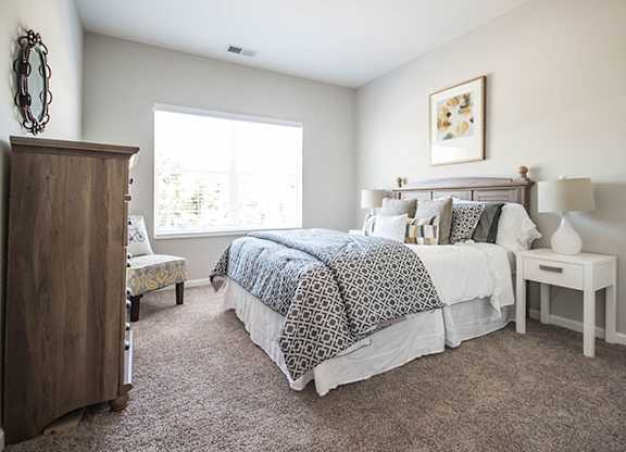 a room with a bed, dresser, and nightstand