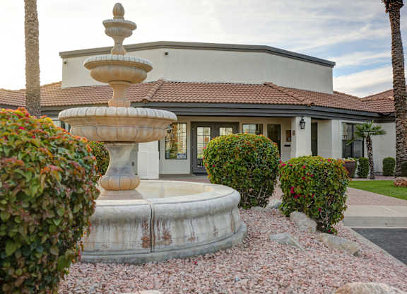 A house with a fountain in front of it.