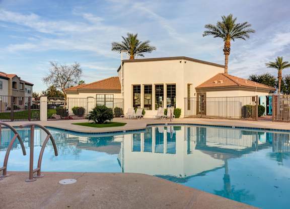 A pool with a building behind it.