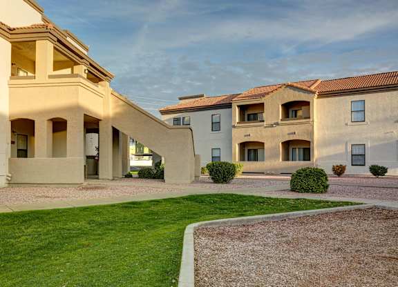 A row of houses with a green lawn in front.