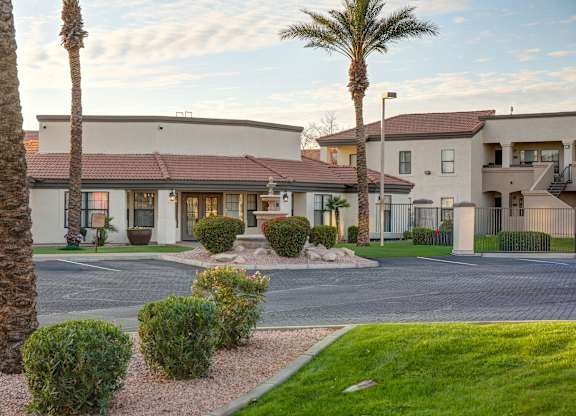A residential area with a building and palm trees.