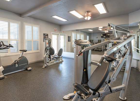 A gym with a treadmill, elliptical trainer and a weight machine at Autumn Oaks Apartments, Roseville, CA, 95678