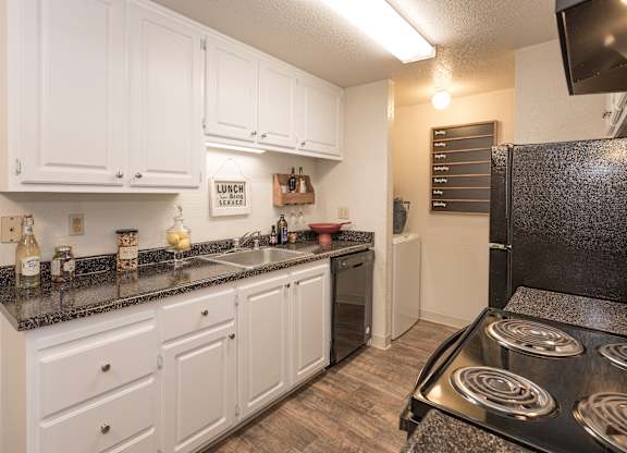 A kitchen with white cabinets and a black stove top.