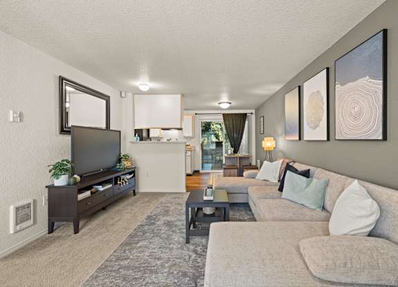 A living room with a grey couch and a television at Clackamas Trails Apartments, Oregon, 97222