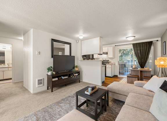 A modern living room with a flat screen TV and a coffee table at Clackamas Trails Apartments, Oregon, 97222