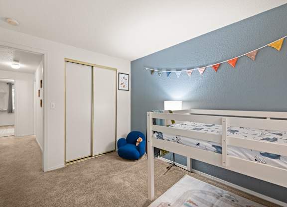 A room with a bed, a chair, and a wall clock at Clackamas Trails Apartments, Oregon, 97222