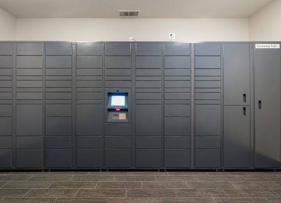 A bank of package lockers with a digital screen in the middle at Clackamas Trails Apartments, Oregon, 97222