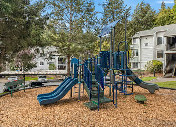 A playground with a blue slide and a green railing at Clackamas Trails Apartments, Oregon, 97222
