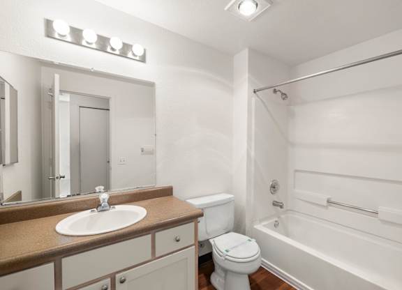 A white bathroom with a sink, toilet, and bathtub at Clackamas Trails Apartments, Oregon, 97222