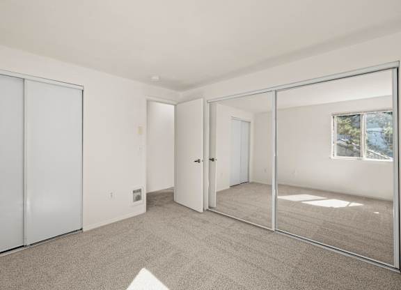 A room with a carpet floor and a mirrored door at Clackamas Trails Apartments, Oregon, 97222