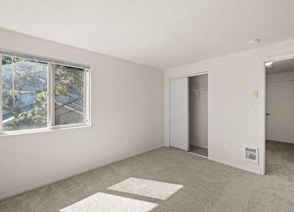 A room with a window, a door, and carpeted floor at Clackamas Trails Apartments, Oregon, 97222
