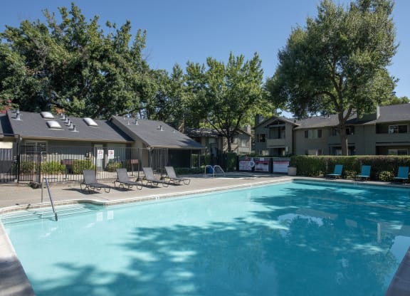 swimming pool with lounge chairs at Delta Pointe Apartments, Sacramento, CA