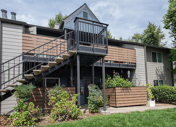 An apartment building with a balcony and stairs leading to the second floor at Pepperwood Apartments, California, 95661