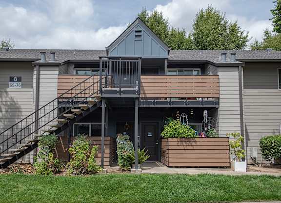 An apartment building with a grey facade and a balcony with a railing at Pepperwood Apartments, California, 95661