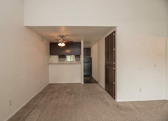 A room with a carpeted floor and a ceiling fan at Pepperwood Apartments, California, 95661