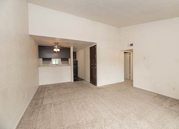 A room with a carpeted floor and a ceiling fan at Pepperwood Apartments, California, 95661