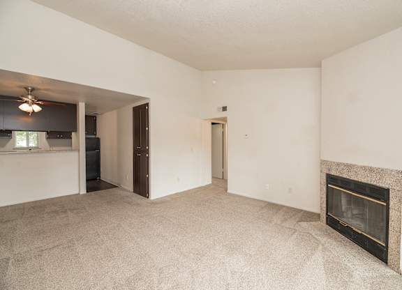 A living room with a fireplace and a carpeted floor at Pepperwood Apartments, California, 95661