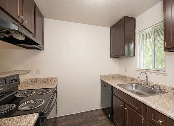 A kitchen with a countertop and a stove top oven at Pepperwood Apartments, California, 95661