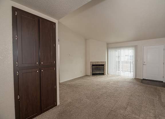 A room with a fireplace and a door on the right at Pepperwood Apartments, California, 95661