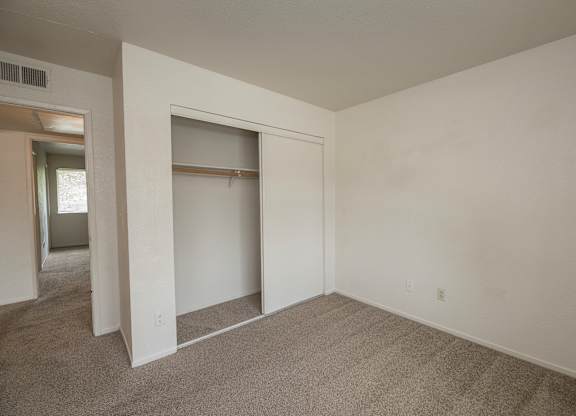 A room with a carpeted floor and a white wall with a doorway leading to another room at Pepperwood Apartments, California, 95661