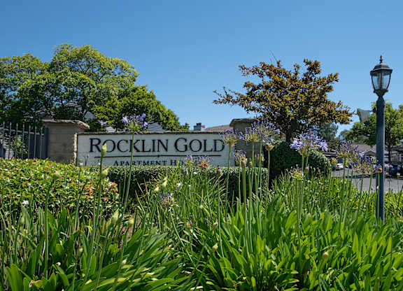 A sign for Rocklin Gold Apartment Homes is surrounded by greenery at Rocklin Gold Apartments, California, 95677
