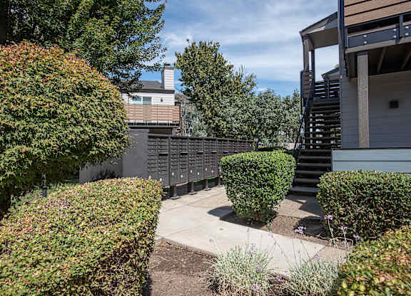 A building with a staircase and a hedge at Sierra Glen Apartments, California, 95621