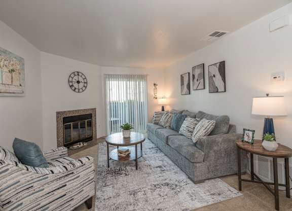 A living room with a fireplace and a striped chair at Sierra Glen Apartments, California, 95621
