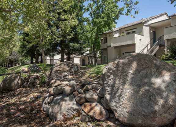 Stanford Heights apartments landscaping boulders and trees in front of a building