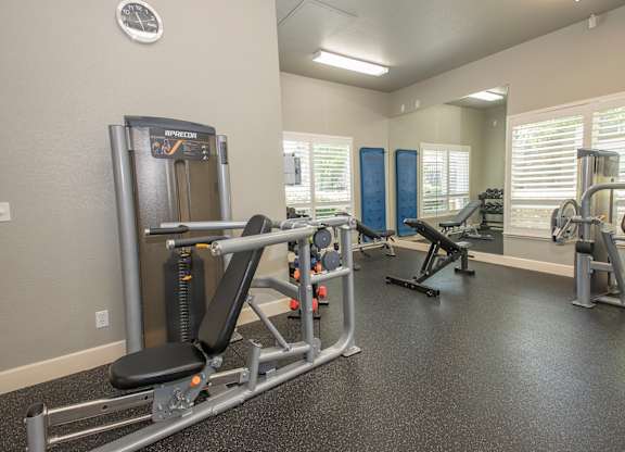 A gym with a variety of equipment including a leg press machine at Stoneridge Apartments, California, 95661
