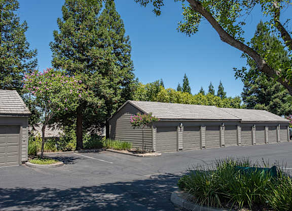 A parking lot with garages and trees at Sunset Summit, Rocklin, CA, 95765