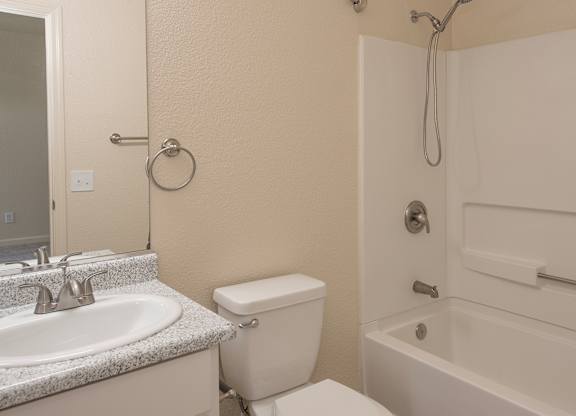 A white toilet sits next to a sink in a bathroom at Sunset Summit, Rocklin, CA, 95765