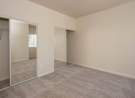 A room with a carpeted floor and mirrored closet doors at Sunset Summit, Rocklin, CA, 95765