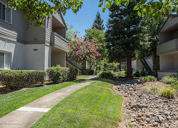 Apartment buildings, a sidewalk, and a grassy area at Sunset Summit, Rocklin, CA, 95765