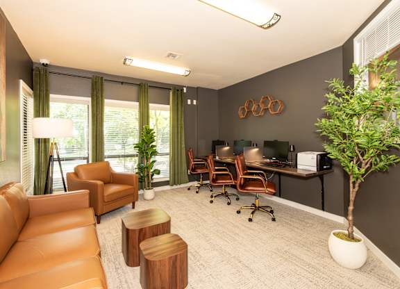 A room with a brown couch, a desk with chairs, and a potted plant at Sunstone Parc, Beaverton, OR, 97008